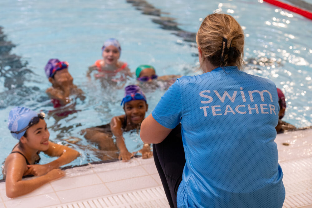 swimming teacher with students in the pool